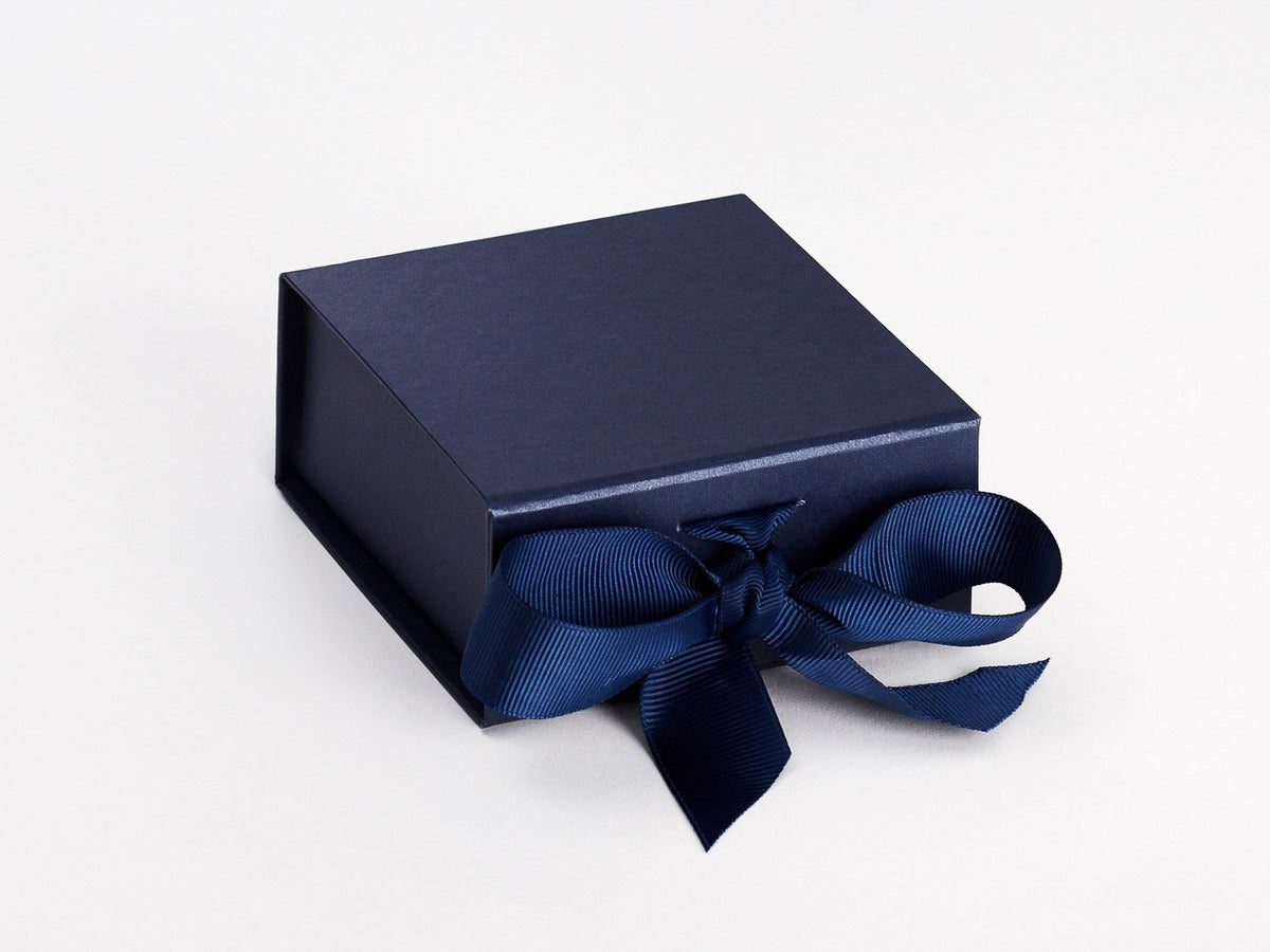 Premium Photo  A gift wrapped in black paper and tied with a gold ribbon.  expensive gift concept.